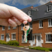 An outstretched hand proudly holds a set of keys aloft, presumably the hand belongs to a first time buyer, holding the keys to their newly purchased property.