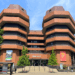 The headquarters of Ealing Council in the Perceval House building are seen from a nearby street. A bright blue sky spreads above, littered with precious few clouds.